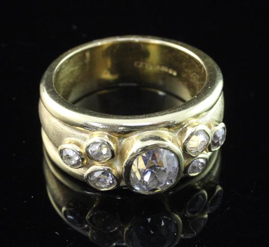 A modern 18ct gold and collet set seven stone diamond dress ring, size M.